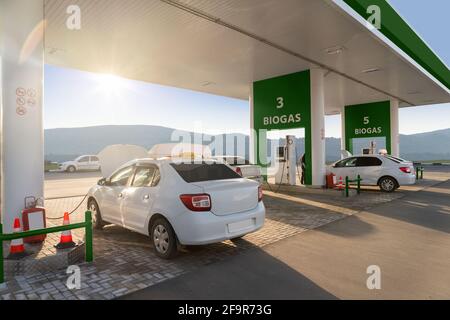 Auto presso la stazione di riempimento biogas. Concetto di trasporto neutro dal carbonio Foto Stock