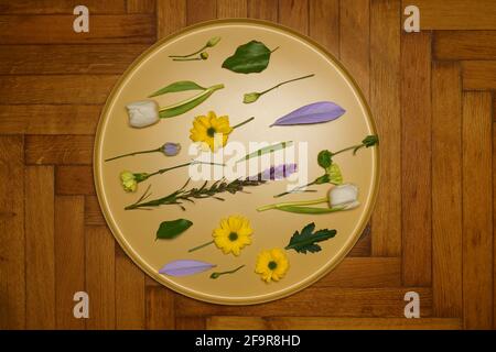 Piatto posare fiori diversi su vassoio rotondo dorato Foto Stock