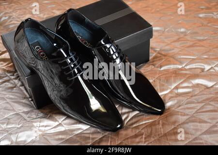Nuove scarpe nere da uomo sul letto Foto Stock