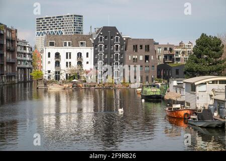 Case galleggianti, vecchi e nuovi appartamenti su un canale ad Amsterdam. Foto Stock