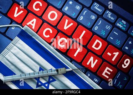 Immunizzazione COVID-19 in Israele con siringa e maschera facciale con bandiera israeliana e messaggio vaccino sulla tastiera del computer. Concetto di vaccinazione di Covid Foto Stock