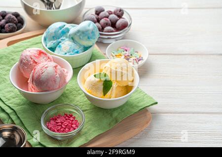 Mango, lampone e gelato alla mora su uno sfondo chiaro con spazio da copiare. Vista laterale, primo piano. Dessert estivo. Foto Stock
