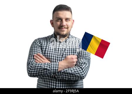Ragazzo bianco che tiene una bandiera del Ciad sorridente fiducioso con le armi incrociate isolate su uno sfondo bianco. Foto Stock