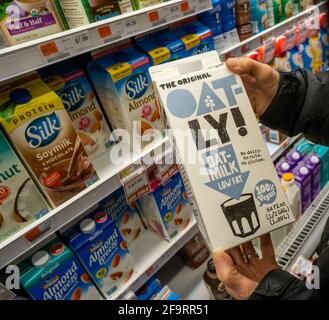 New York, Stati Uniti. 16 Apr 2018. Un consumatore esigente sceglie un contenitore da mezzo gallone di Oatly! Marca latte-avena nel frigorifero a base di piante in un supermercato a New York n Lunedi, 16 aprile 2018. Secondo quanto riportato, la Oatly Group AB ha presentato domanda per un IPO. (Foto di Richard B. Levine) Credit: Sipa USA/Alamy Live News Foto Stock