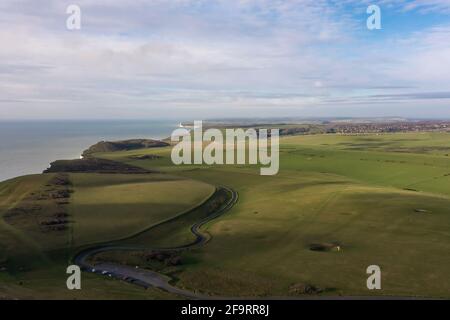 Bella campagna e strada costiera con lussureggiante erba verde su una scogliera, Beachy Head vicino Eastbourne vista aerea Foto Stock