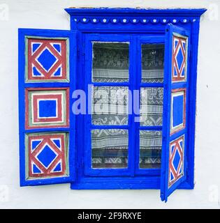 Tradizionale in legno finestra blu contro il muro bianco Foto Stock