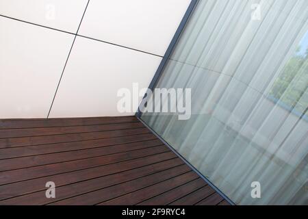 Ponte in legno di pino, trattamento di legno di conifere terrazza a contrasto con pannelli di facciata bianca e grande finestra in vetro, dettaglio architettura di casa moderna desi Foto Stock