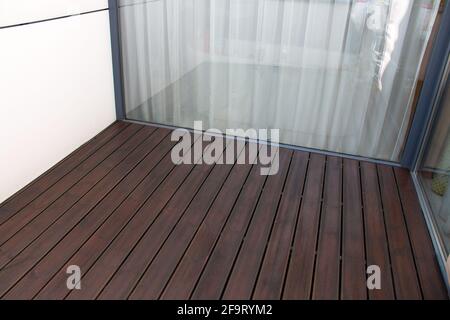 Ponte in legno di pino e grande finestra di vetro, terrazza di legno di conifere trattato, frammento architettonico Foto Stock