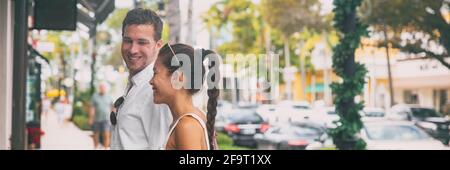 Felice coppia interracial che parla camminando sul panorama della strada dello shopping della città. Giovane uomo e donna asiatica guardando insieme la vetrina del negozio, Napoli Foto Stock