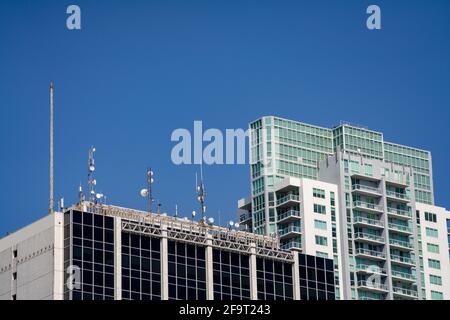 Piatti satellitari sul tetto di un edificio d'ufficio Foto Stock