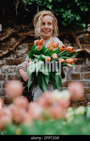 Una donna che tiene un mazzo di fiori di tulipano Foto Stock