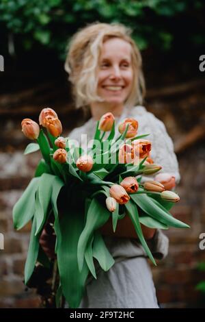 Una donna che tiene un mazzo di fiori di tulipano Foto Stock