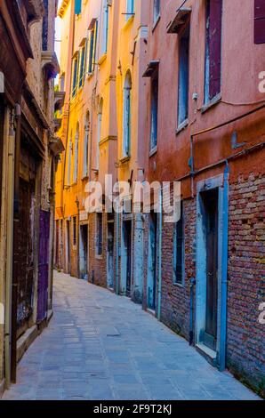 vista di una stretta strada in mattoni nella città italiana di venezia Foto Stock