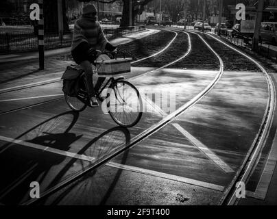 Un ciclista che passa attraverso una strada ad Amsterdam Foto Stock