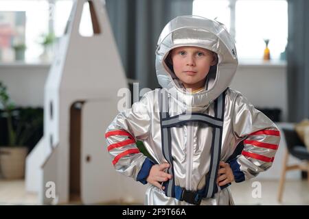 Dolce bambino, vestito da astronauta, giocando a casa con razzo di cartone  e casco fatto a mano da scatola Foto stock - Alamy