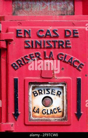 Dettaglio di un vecchio terminale di chiamata di emergenza del dipartimento dei vigili del fuoco in Francia, con una frase scritta in francese: "In caso di disastro, rompere il vetro" Foto Stock