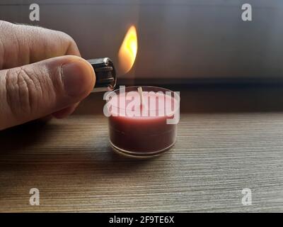 Candela di illuminazione con un accendisigari. Accendino a mano con fiamma  Foto stock - Alamy