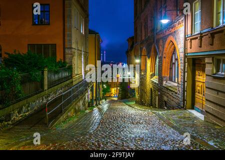 Vista notturna di una strada illuminata sull'isola di Sodermalm nel centro di Stoccolma, Svezia. Foto Stock