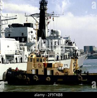 AJAXNETPHOTO. 24 AGOSTO 2001. PORTSMOUTH, INGHILTERRA. - PRONTO PER LO SPETTACOLO. - IL TIPO 23 CLASSE FREGATA HMS MONMOUTH OTTIENE ASSISTENZA DAL TUNG SETTER COME SI BERTHS AL MOLO DI RNB MIDDLE SLIP PER PREPARARSI PER LA SUA PARTE IN IFOS 2001. FOTO:JONATHAN EASTLAND/AJAX. REF:230801 33 02 Foto Stock