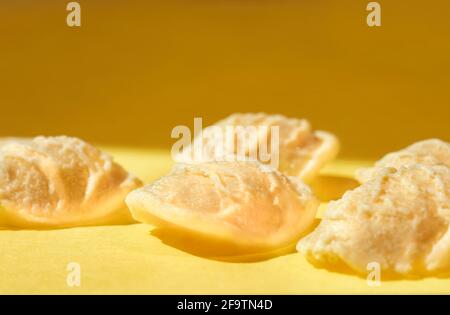 Pasta orecchiette su sfondo colorato, una pasta a forma di orecchio piccolo con il centro più sottile del bordo e un ruvido superficie Foto Stock