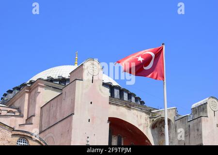 Sventolando la bandiera turca di fronte a Hagia Sophia (costruita nel VI secolo d.C.) a Istanbul, Turchia. Visto dall'esterno del complesso. Foto Stock