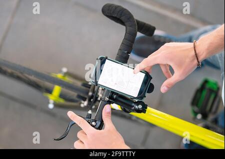 Uomo che consulta la mappa con un'app per conoscere i luoghi e fare consegne con la bicicletta. Foto Stock