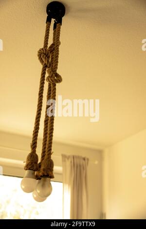 Scatto verticale di lampadine con corde appese da a. soffitto Foto Stock