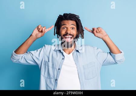 Ritratto di simpatico ragazzo allegro che indossa una camicia in jeans dimostrando nuove taglio isolato su sfondo di colore blu brillante Foto Stock