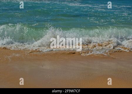 Onde che si avvolgono su spiaggia di sabbia - primo piano Foto Stock