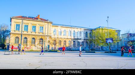 RUSE, BULGARIA, 7 MARZO 2015: Il gruppo di bambini gioca a calcio su un campo di cemento situato nell'areal della scuola elementare in ruse. Foto Stock