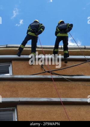 NOVI SAD, SERBIA - 21 maggio 2019: Novi Sad, Serbia, 21 maggio 2019. - pompieri che scendono una corda dal tetto - esercizio dimostrativo Foto Stock