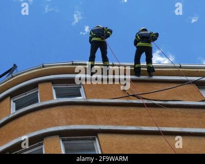 NOVI SAD, SERBIA - 21 maggio 2019: Novi Sad, Serbia, 20 maggio 2019. - pompieri che scendono una corda dal tetto - esercizio dimostrativo Foto Stock