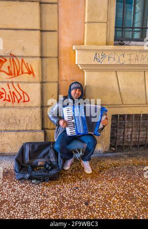 BOLOGNA, 17 MARZO 2016: Dettaglio di un musicista di strada che suona l'armonica nella città italiana di Bologna Foto Stock