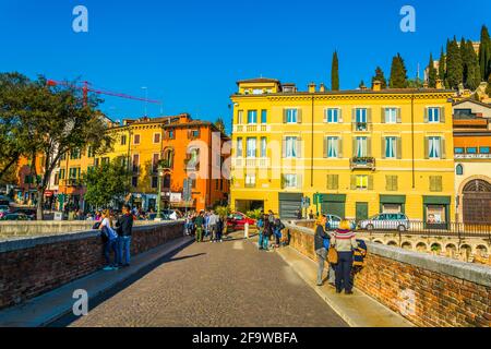 VERONA, 19 MARZO 2016: I turisti attraversano il ponte pietra a Verona Foto Stock