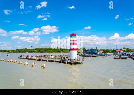 PODERSDORF, AUSTRIA, 9 LUGLIO 2016: I giovani sono kite surf vicino famoso faro rosso e bianco a Podersdorf am See in Austria.Town. Foto Stock