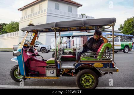 Bangkok, Thailandia. 19 Apr 2021. Un autista di tuk tuk thailandese attende i clienti sulla strada. Il classico taxi Tuk Tuk Tuk è famoso a livello internazionale. Il taxi a tre ruote è un modo popolare di trasporto locale non-metered per la gente del posto e i turisti, la tariffa è negoziata in base alla distanza. Il risciò motorizzato tailandese, è un simbolo della nazione. Credit: SOPA Images Limited/Alamy Live News Foto Stock