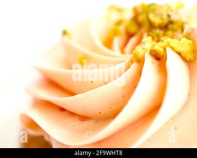 Macro primo piano su un cupcake con glassa rosa Foto Stock