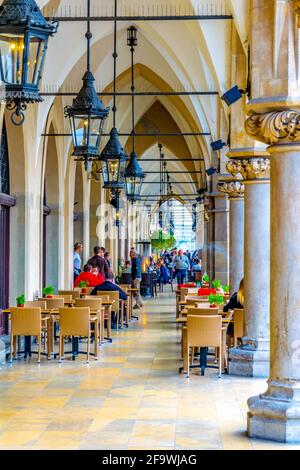 CRACOVIA, POLONIA, 11 AGOSTO 2016: La gente sta pranzando sotto gli archi del mercato di sukiennice nella città polacca Cracovia. Foto Stock