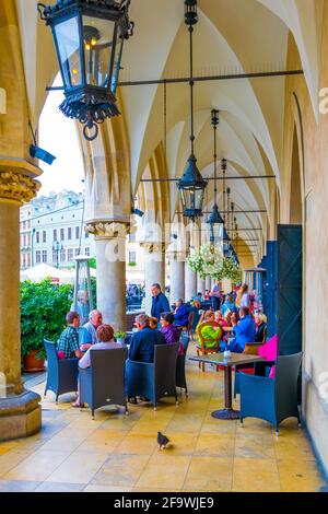 CRACOVIA, POLONIA, 11 AGOSTO 2016: La gente sta pranzando sotto gli archi del mercato di sukiennice nella città polacca Cracovia. Foto Stock