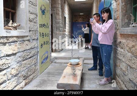 (210421) -- JINJIANG, 21 aprile 2021 (Xinhua) -- i visitatori scattano foto dell'opera d'arte di Cai Jingxiang con le derive marine nella sua sala espositiva delle derive marine a Jinjiang City, nella provincia del Fujian, nel sud-est della Cina, il 20 aprile 2021. Il CAI Jingjiang, un designer di annunci pubblicitari di carriera, è tornato cinque anni fa alla sua città natale al villaggio di Tangdong, città di Jinjiang. Trovò ispirazione dalle derive marine lavate a riva vicino al suo villaggio, molte delle quali in forme uniche. Un giorno dopo l'altro, Cai ha cercato attraverso la spiaggia e ha portato a casa derive con il potenziale artistico, e li ha trasformati in Foto Stock