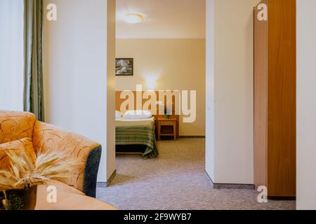 Interno di una camera d'hotel semplice e ben arredata camera da letto separata durante il giorno Foto Stock