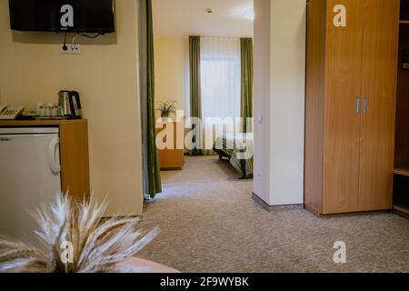Interno di una camera d'hotel semplice e ben arredata camera da letto separata durante il giorno Foto Stock