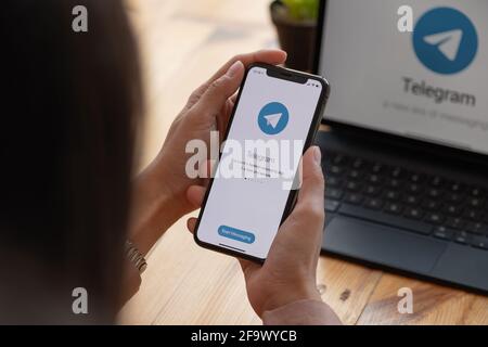 CHIANG mai, THAILANDIA, 21 MARZO 2021 : Donna mano che tiene iPhone X con servizio di social networking Telegram sullo schermo. IPhone 10 è stato creato e. Foto Stock