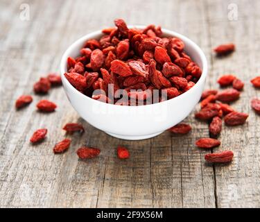 Bacche rosse di goji asciutte per una dieta sana su a. vecchio sfondo di legno Foto Stock