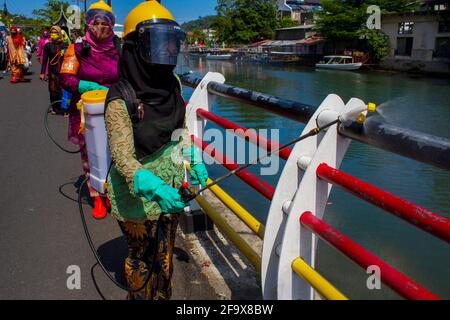 Padang, Indonesia. 21 Apr 2021. I volontari che indossano tute protettive disinfettanti spray nelle aree pubbliche durante l'epidemia di COVID-19 come parte della commemorazione della Giornata Kartini a Padang, West Sumatra, Indonesia, 21 aprile 2021. Il giorno di Kartini viene commemorato il 21 aprile di ogni anno per celebrare la nascita di Raden Ajeng Kartini, eroina nazionale indonesiana nata nel 1879 e pioniera nel campo dei diritti delle donne. Credit: Vivi Hutagalung/Xinhua/Alamy Live News Foto Stock