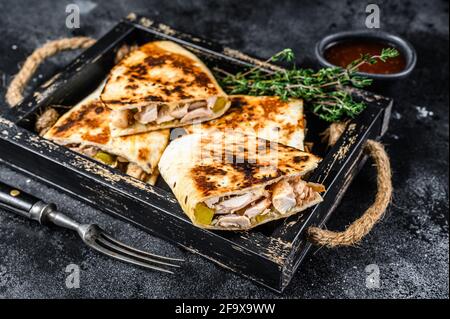 Quesadilla messicana con pollo, pomodoro, mais e formaggio. Sfondo nero. Vista dall'alto Foto Stock