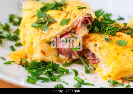 Frittata con prosciutto e formaggio con erba cipollina, primo piano. Foto Stock