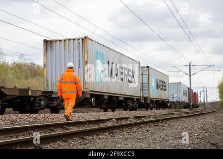 DONCASTER, REGNO UNITO - 4 APRILE 2021. Un operaio ferroviario che ispeziona un treno merci container Maersk sulla rete ferroviaria del Regno Unito prima dell'esportazione o dell'importazione. Foto Stock