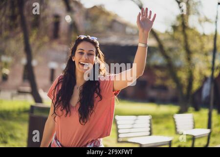 Felice giovane donna sta godendo di una giornata di sole all'aperto in città. Foto Stock