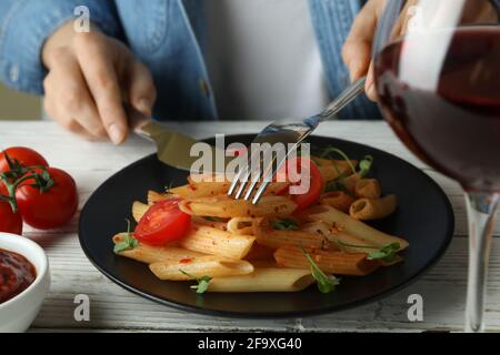 Concetto di mangiare gustoso con la donna mangia la pasta con salsa di pomodoro, primo piano Foto Stock